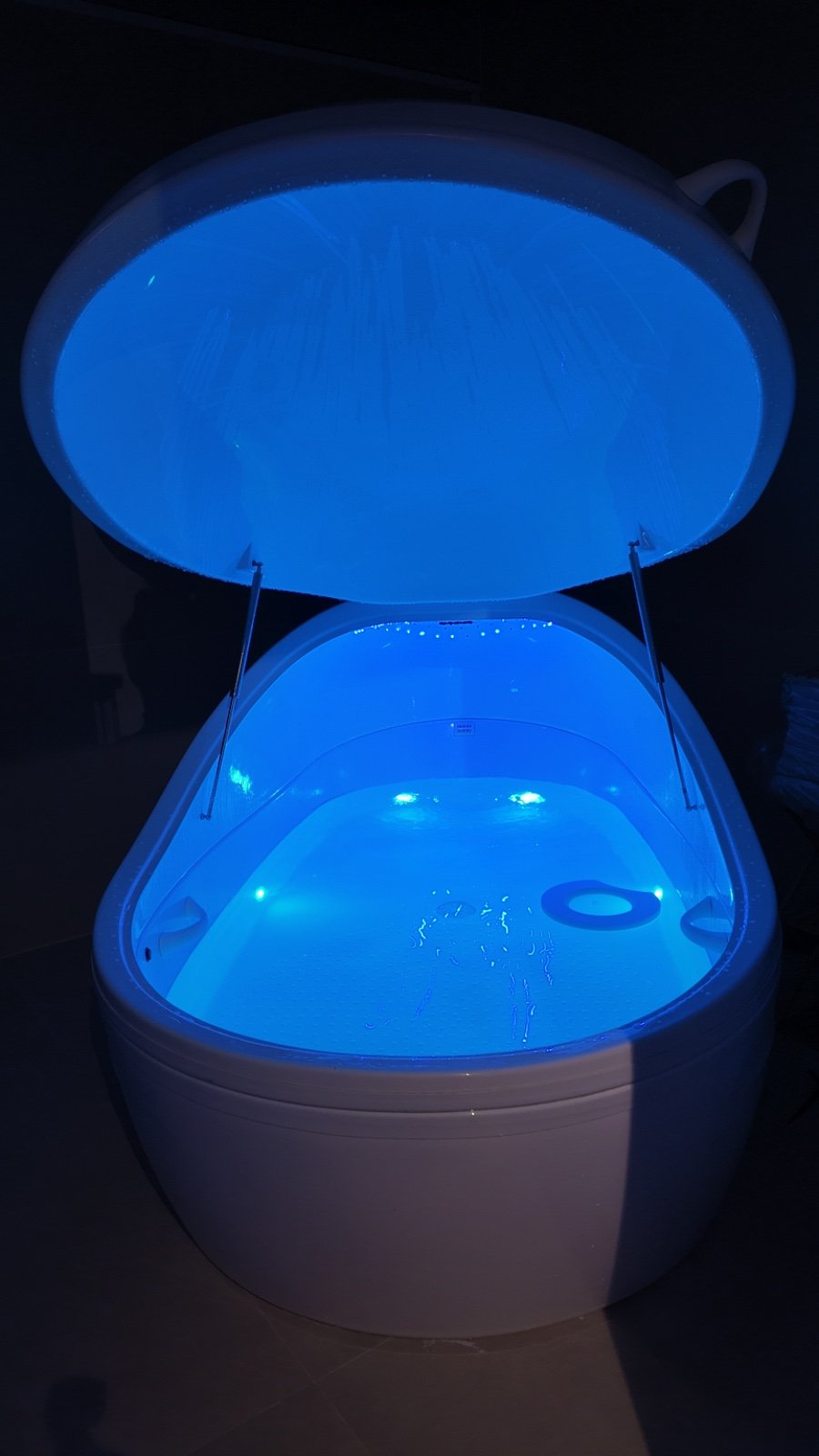 De float pod van Sacred Floating, zacht verlicht in een donkere ruimte